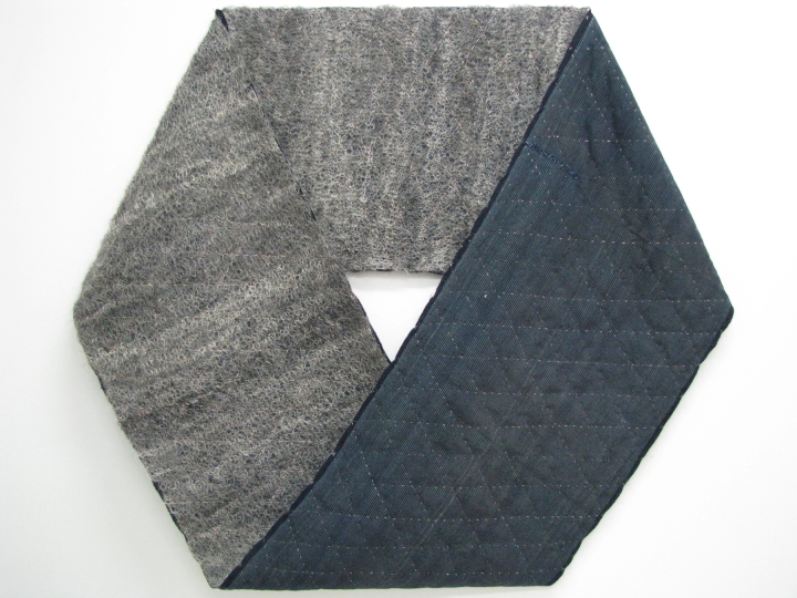 A Möbius made of two layers of fabric: hand spun, hand knitted grey mohair and blue cotton fabric unpicked from a kimono. It is folded flat so it forms a hexagram shape with a trianglular opening in the centre.